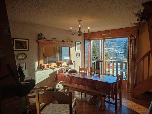 une salle à manger avec une table et une grande fenêtre dans l'établissement Le Montagnard, à Demi-Quartier