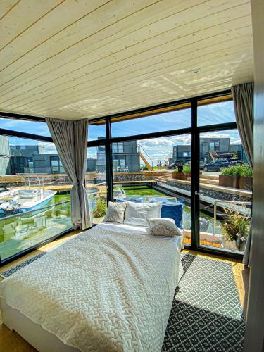 1 dormitorio con 1 cama frente a una ventana grande en Twin Boat, en Ekerö