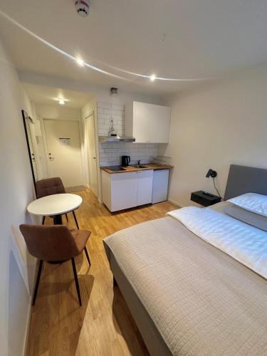 a bedroom with a bed and a table and a kitchen at Edsviken Hotell AB in Stockholm