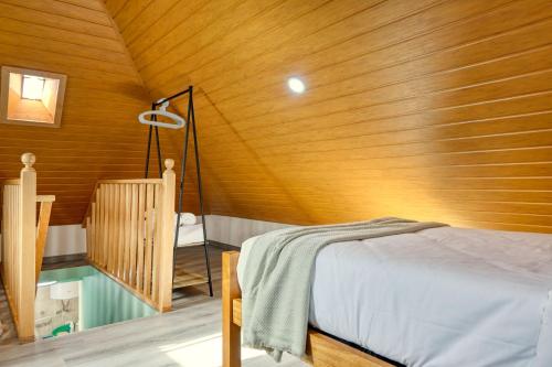 a bedroom with a bed and a wooden wall at Atlantic View, a Home in Madeira in Ponta do Sol