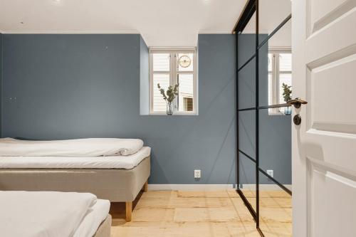 ein Schlafzimmer mit 2 Betten und einer blauen Wand in der Unterkunft 100m to Bryggen I Lux Feeling & Private Patio in Bergen