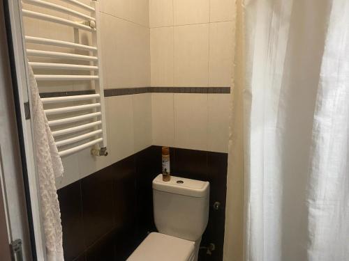 baño con aseo blanco y azulejos blancos y negros en G Apartment, en Tiflis