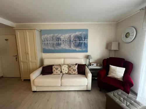 a living room with a white couch and a chair at La casa di Ele in Morgex