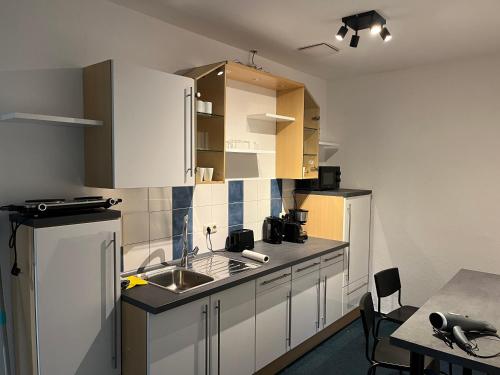 a kitchen with white cabinets and a sink at 4rooms - Bamberger Gemütlichkeit in Bamberg