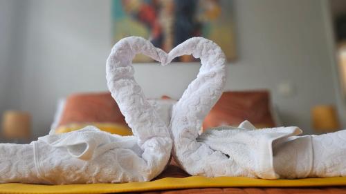 a pair of white towels forming a heart at Spa Serviced Apartments LUNA R&R 