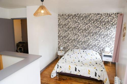 een slaapkamer met een bed en een muur bij Duplex hyper centre : Le Cosy in Niort