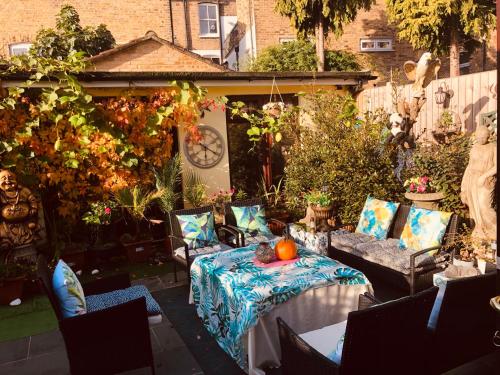 a patio with a table and chairs in a garden at Cheerful 4 bedroom house with garden free parking in London