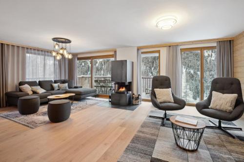 a living room with a couch and chairs and a fireplace at Chalet Les Rahâs by Mrs Miggins in Grimentz