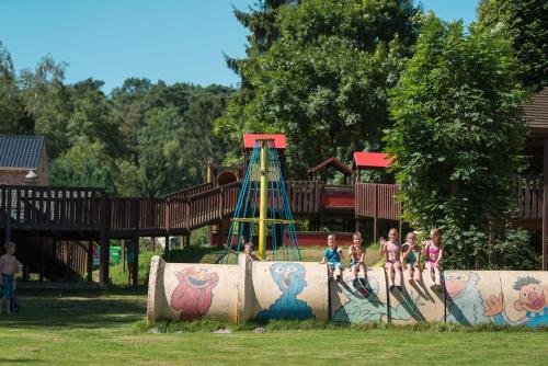 a group of children standing in front of a playground at Jocomo Parc in Lanaken