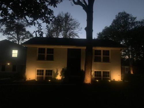 a house with a tree in front of it at night at Serene Lush 2BR Gem, on 1 acre Silver Spring in Silver Spring