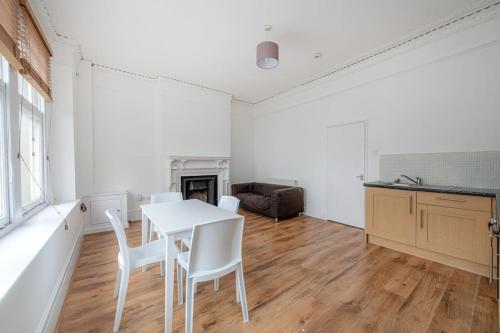 una sala da pranzo bianca con tavolo e sedie di Central Muswell Hill- One Bed a Londra