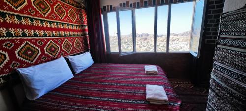 um quarto com uma cama num quarto com uma janela em Rocky Mountains Hotel em Wadi Musa