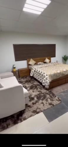 um quarto branco com 2 camas e um tapete em استراحة لازورد -Lazord rest em Al Ḩamrānīyah