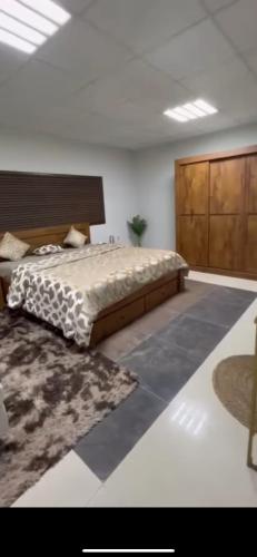 1 dormitorio con 1 cama grande y 1 alfombra en استراحة لازورد -Lazord rest, en Al Ḩamrānīyah
