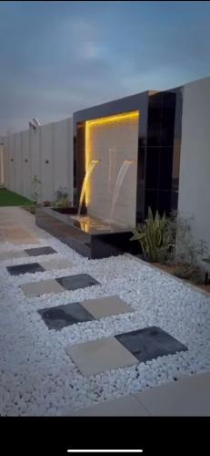 a stone walkway with a fireplace in a backyard at استراحة لازورد -Lazord rest in Al Ḩamrānīyah