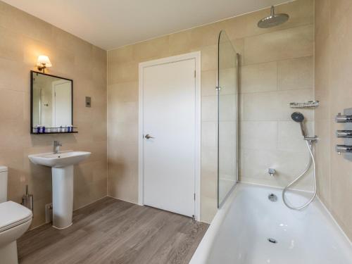 a bathroom with a shower and a tub and a sink at 3 Bed in St. Mellion 87711 in St. Mellion