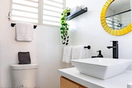 Baño blanco con lavabo y espejo en Seaside Serenity - Cozy Studio, en Luquillo