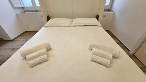 a large bed with three pillows on it in a room at Casteddu Cagliari centro in Cagliari