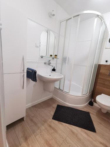 a white bathroom with a sink and a shower at Apartament "Natalia" Pszczew Lubuskie Mazury in Pszczew