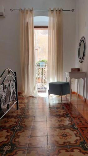 een woonkamer met een stoel en een raam bij Casa Curu in Sciacca