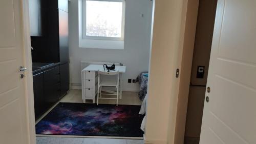 a room with a table and a cat sitting on a stool at 2- bed Apartment in Sollentuna in Sollentuna