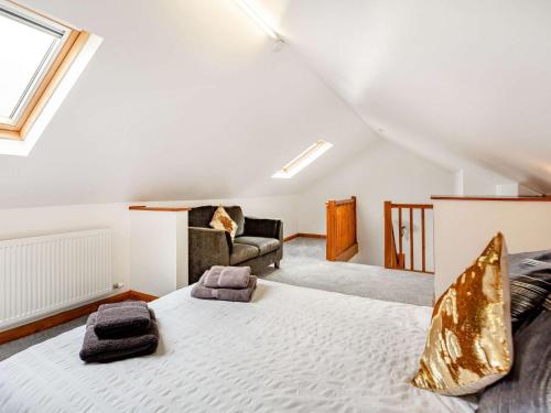 1 dormitorio en el ático con 1 cama grande y 1 sofá en 4 Bed in Denbigh 62368, en Denbigh