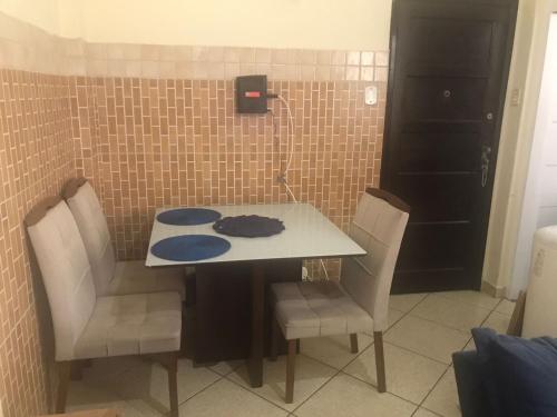 una mesa y sillas en una habitación con una pared de azulejos en Apto Olaria en Río de Janeiro
