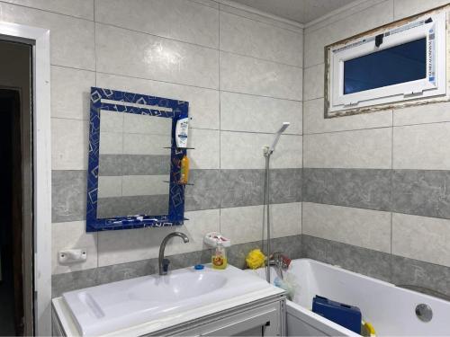 a bathroom with a sink and a tub and a mirror at Très belle appartement in Constantine