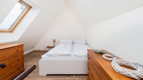 a bedroom with a white bed and a wooden dresser at Kierpcówka, Sun & Snow in Kościelisko
