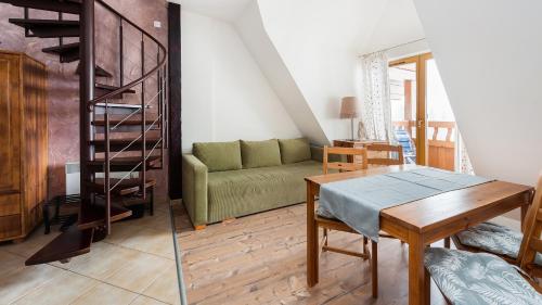 a living room with a green couch and a table at Kierpcówka, Sun & Snow in Kościelisko