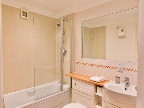 y baño con bañera de ducha y lavamanos. en Your Space Apartments - Manor House, en Cambridge