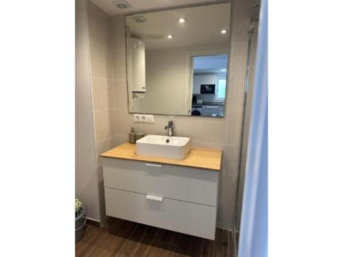 ein Badezimmer mit Waschbecken und Spiegel in der Unterkunft Apartamento de 2 habitaciones en primera línea con vistas al mar in Platja de l'Arenal