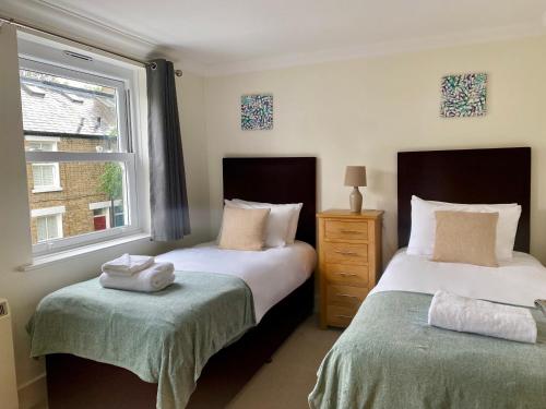 1 dormitorio con 2 camas y ventana en Your Space Apartments - Manor House, en Cambridge