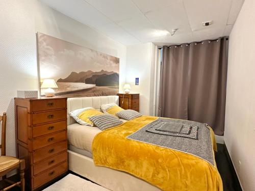 a bedroom with a bed and a dresser at Loft de l'armateur in Fécamp