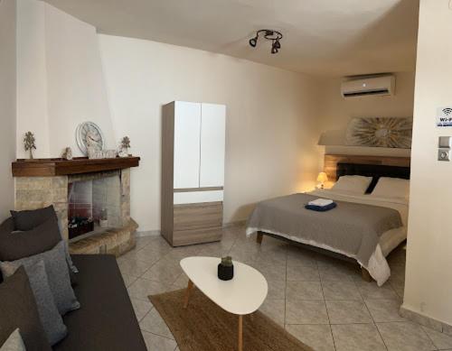 1 dormitorio con 1 cama y chimenea en Garden Square Inn en Markópoulon