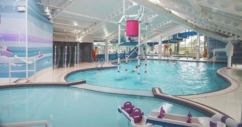 a large indoor swimming pool with people in it at BrookeView Caravan Rental, Seton Sands in Port Seton