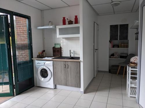 cocina con lavadora en una habitación en Le METROPOLITAIN, en Laniscat