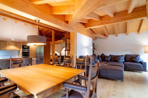a dining room and living room with a wooden table at Apart-Hotel Laurus Lech in Lech am Arlberg