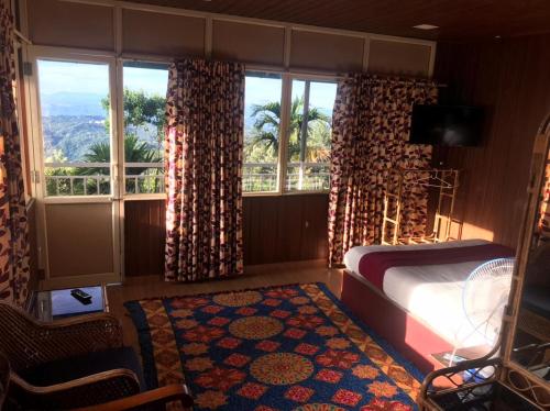 um quarto com uma cama e uma grande janela em Nature Dale Munnar em Munnar