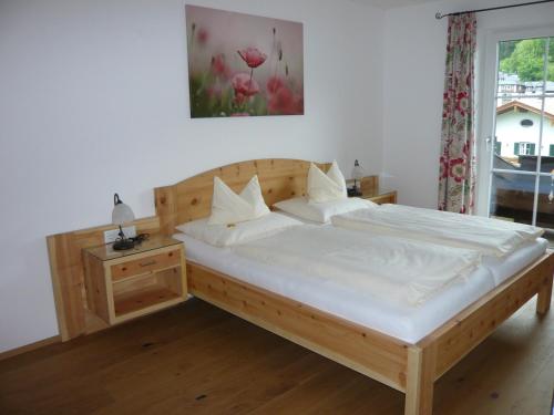 a bedroom with a large bed with white sheets at Pension Wörndl in Fuschl am See