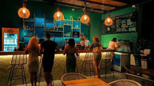 a group of people standing at a bar in a restaurant at Viajero Santa Marta Hostel in Santa Marta