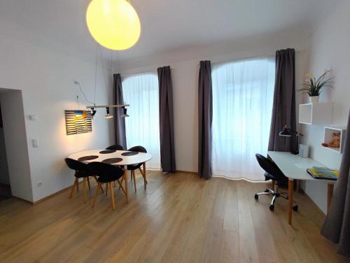 - un salon avec une table, des chaises et un bureau dans l'établissement Altstadtwohnung Traunstein mit Traunseeblick 1A, à Gmunden