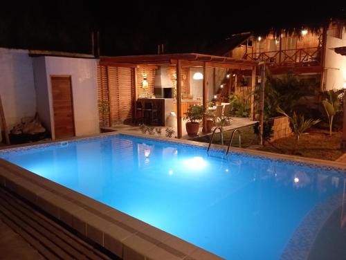 a large blue swimming pool at night at Costa Luna in Vichayito
