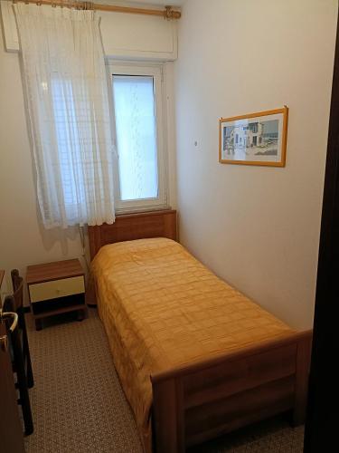 - une petite chambre avec un lit et une fenêtre dans l'établissement Casa Diana, à Bibione