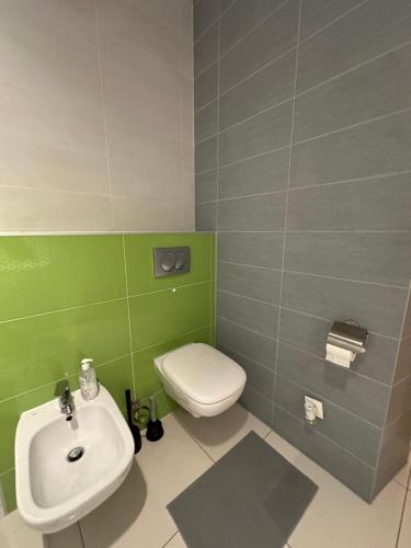 a bathroom with a white toilet and a sink at City Center Apartment in Krakow