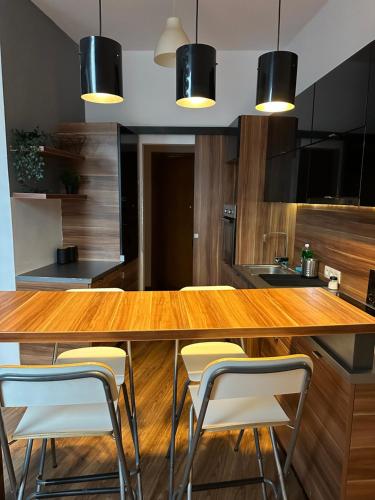 uma cozinha com um balcão de madeira com bancos em City Center Apartment em Cracóvia