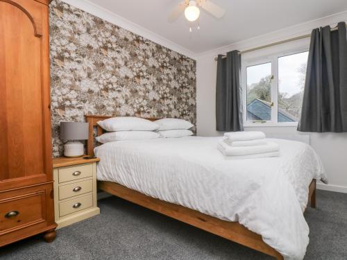 - une chambre avec un grand lit et une fenêtre dans l'établissement Chellowdene Cottage, à Falmouth