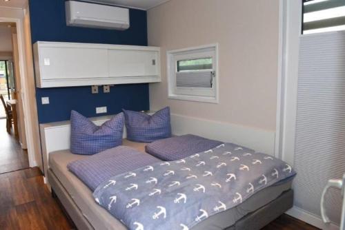 um quarto com uma cama com paredes azuis e almofadas roxas em Hausboot Dolce Vita em Klitten