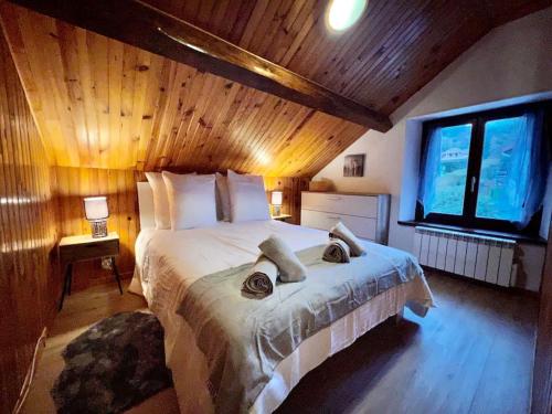 - une chambre avec un grand lit blanc et un plafond en bois dans l'établissement Le Jardin d’Eden, superbe gîte, borne recharge VE, à Gérardmer