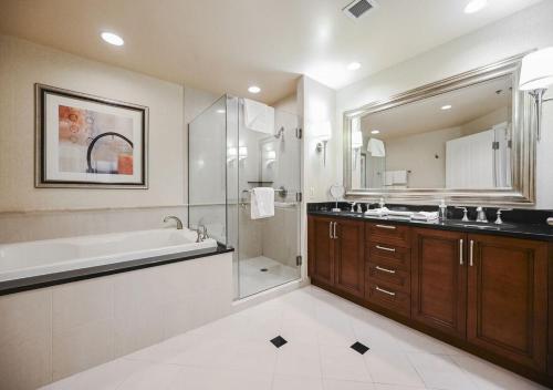La salle de bains est pourvue d'une baignoire, d'un lavabo et d'une douche. dans l'établissement Beautiful Strip View Studio In LV, à Las Vegas
